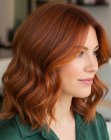 Cabello castaño rojizo a la altura de los hombros con ondas y reflejos cobrizos